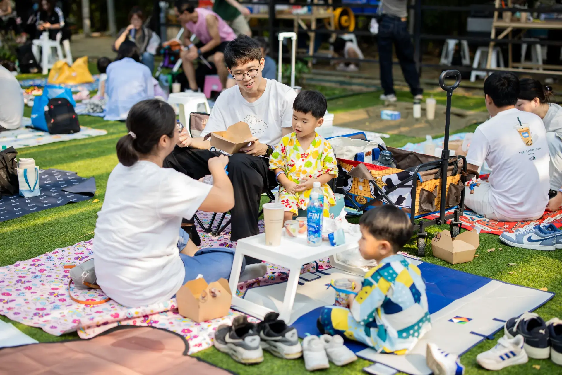 一家人坐在野餐墊上享用午餐